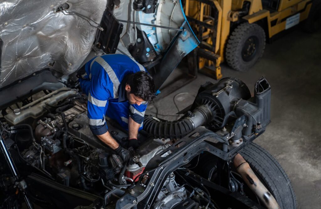 Diesel mechanic repairing a heavy-duty truck engine