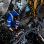 Diesel mechanic repairing a heavy-duty truck engine