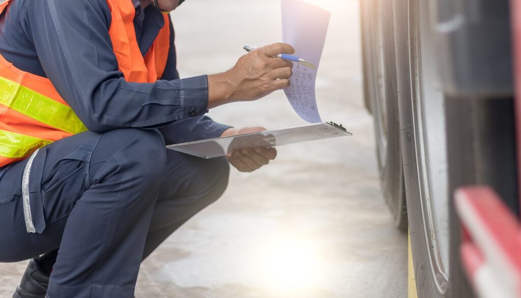 Pre-trip DOT inspection of a heavy truck with a clipboard