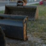 Excavator buckets lined up in a yard