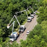 Utility bucket trucks on a rural road
