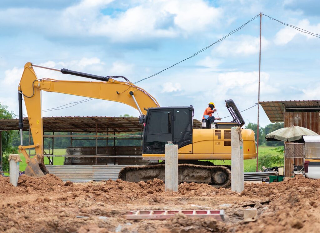 Mechanic performing engine maintenance on an excavator at a job site