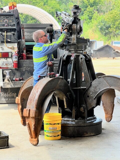 Heavy Equipment Repair mechanic servicing a scrap grapple at the SLM Recycling yard in Carrollton, GA