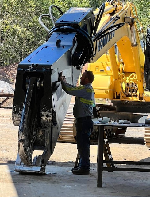 Mechanic repairing a Komatsu excavator in the Heavy Equipment Repair shop in Carrollton, GA